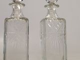 two small glass bottles sitting next to each other on a table