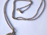 une chaîne en argent avec un pendentif en or sur lequel figure le portrait d'une femme