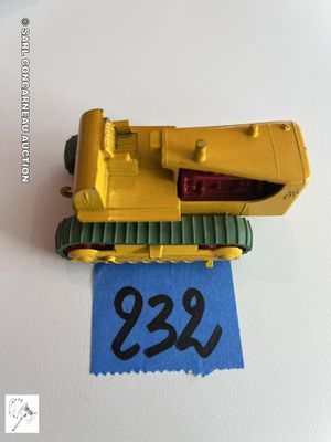 un petit bulldozer jaune en jouet sur une feuille de papier bleue