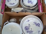 une boîte remplie d'assiettes et de bols posée par terre