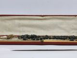 a bead necklace in a red case with a pair of scissors