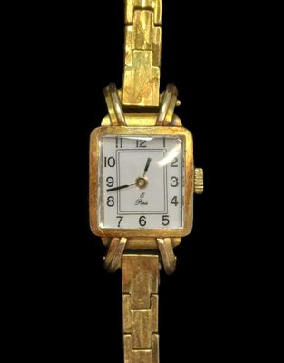 une montre-bracelet en or avec un cadran blanc sur fond noir