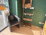 a black chair sitting in front of a window in a room
