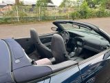 a blue convertible car parked on the side of the road