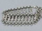 a close up of a silver bracelet on a white surface