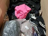 a cardboard box filled with clothes and a pink shirt