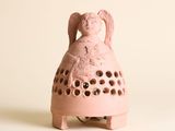 une petite clochette rose sur laquelle est représenté un personnage