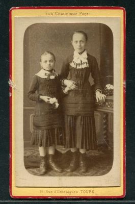 une vieille photo en noir et blanc représentant deux jeunes filles debout l'une à côté de l'autre