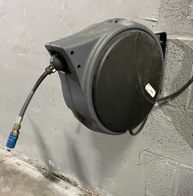 un tuyau d'arrosage fixé sur le côté d'un mur