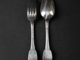 two spoons and a fork on a black surface