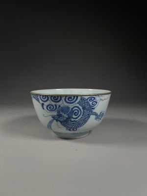 blue and white bowl with a dragon design on the side