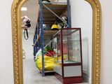 un grand miroir avec un cadre doré dans une pièce