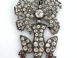 a close up of a brooch with a bird on it