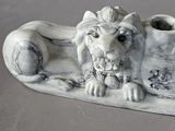 a white lion statue on top of a white vase