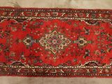 a red rug on a wooden floor with a white background