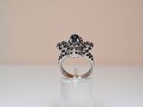 an image of a ring with a black stone on top of a clear stand