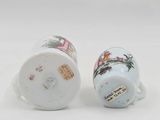 pair of porcelain mugs with floral designs on them on a white surface