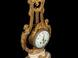 a clock that is sitting on a pedestal on a black background