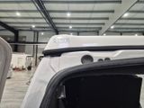 a white truck parked inside of a building with its door open