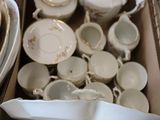 a box full of dishes and cups on the floor
