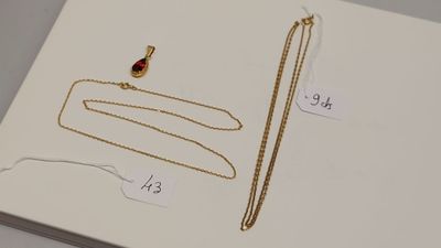 un gros plan d'une boîte sur laquelle sont posés un collier et une chaîne