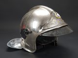 silver helmet on a black background with a red and blue badge on it
