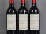 trois bouteilles de vin rouge sont alignées sur une table