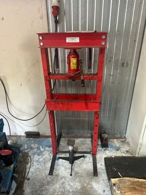 une borne d'incendie rouge posée sur un socle dans un garage