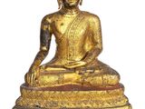 une image représentant une statue de Bouddha dorée assise sur une surface blanche