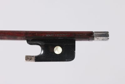 une image représentant un archet de violon posé sur une surface blanche, sur fond blanc