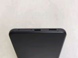 a close up of the back of a black phone on a white surface