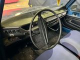 a steering wheel and dashboard of a car in a garage