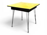 une table jaune aux pieds noirs sur fond blanc