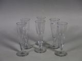 four empty wine glasses sitting on a table with a white background