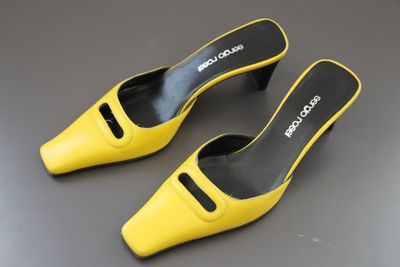 a pair of yellow shoes on a grey surface