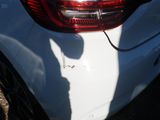 a shadow of a person on the back of a white car