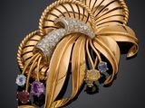 un gros plan d'une broche en or sertie de pierres de différentes couleurs