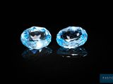 a pair of blue topaz diamonds on a black background