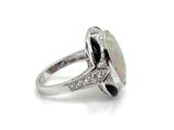 an oplite and diamond ring on a white background