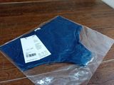 un sac en tissu bleu posé par terre à côté d'une paire de ciseaux