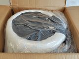 a cardboard box with a toilet in it that is wrapped in plastic