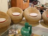 several wicker chairs and tables in a living room with a glass table