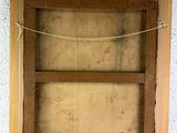 an old picture of a wooden frame hanging on a white wall