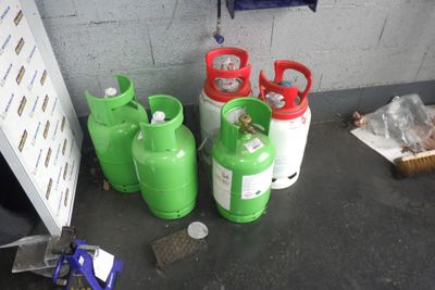 trois bouteilles de gaz propane posées les unes à côté des autres sur le sol