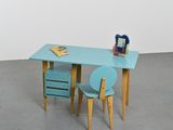 a blue desk with two chairs and a book on it