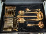 a lot of gold spoons and spoons in a case