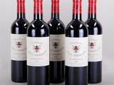 four bottles of red wine are lined up in a row