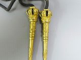 pair of gold plated keys on a black cord with a chain