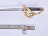 a sword with a gold handle next to a metal tube