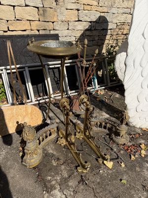 une petite table sur laquelle se trouve un bain d'oiseaux, devant un mur de pierre